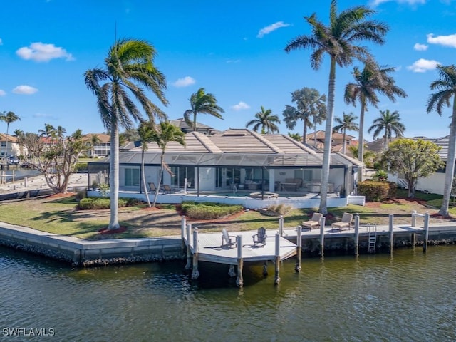 dock area featuring glass enclosure, a yard, and a water view