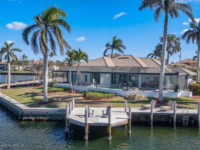 dock area featuring a lawn, glass enclosure, and a water view