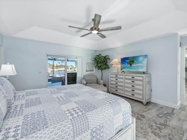 bedroom featuring a tray ceiling, ceiling fan, and access to outside