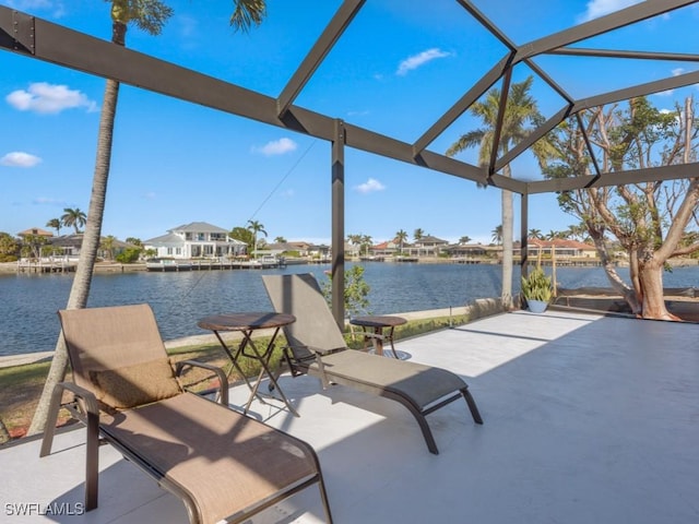 view of patio / terrace featuring a lanai and a water view