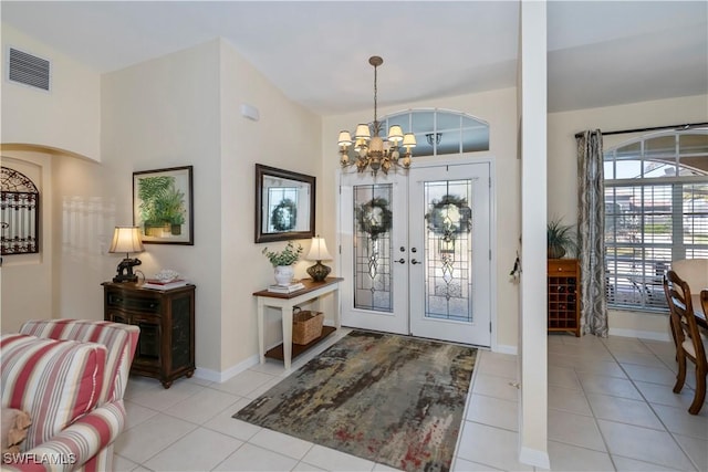 entryway featuring french doors, an inviting chandelier, and light tile patterned floors