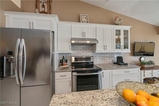 kitchen featuring lofted ceiling, white cabinets, decorative backsplash, and appliances with stainless steel finishes