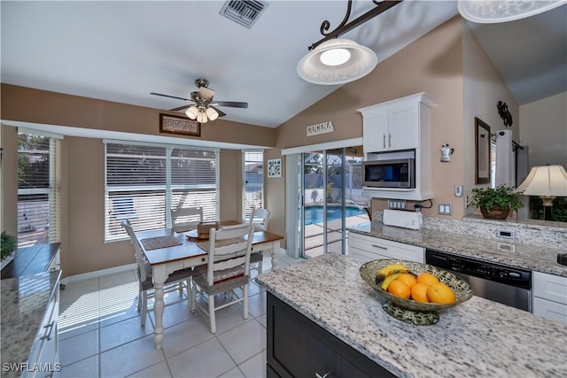 kitchen featuring light stone countertops, hanging light fixtures, light tile patterned floors, white cabinets, and appliances with stainless steel finishes