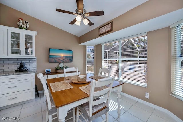 dining area with vaulted ceiling, light tile patterned flooring, and a healthy amount of sunlight