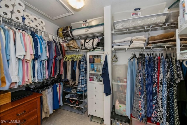 walk in closet with light tile patterned floors