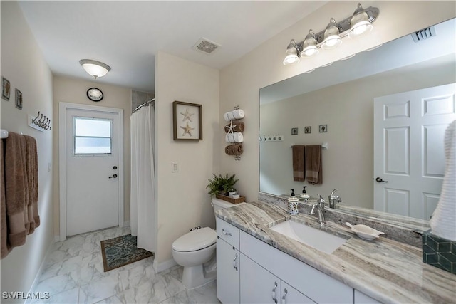 bathroom with toilet, vanity, and curtained shower