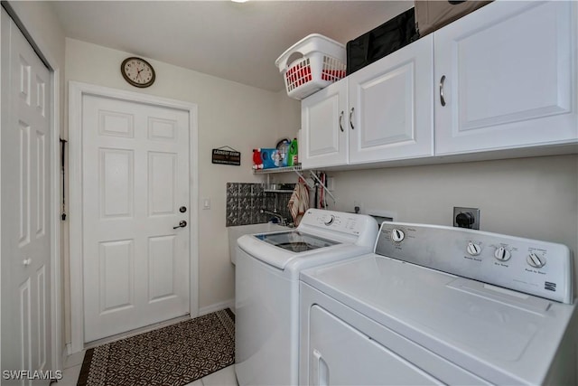 washroom with washer and dryer, cabinets, and light tile patterned floors