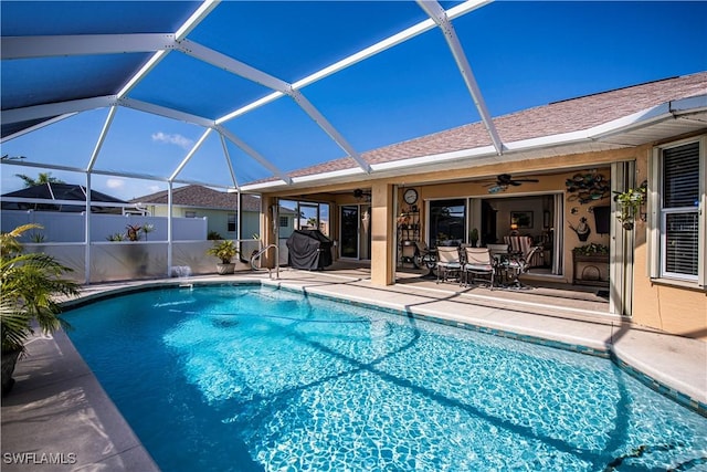 view of pool with ceiling fan, a patio, and glass enclosure