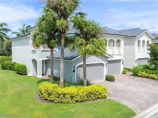 view of front facade with a front yard, a balcony, and a garage