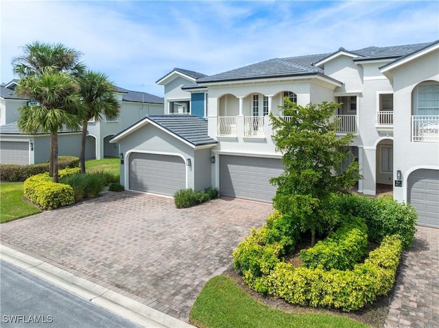 view of front of home with a garage and a balcony