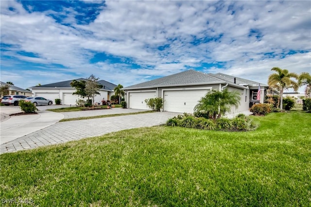 view of front facade featuring a garage, a front lawn, and decorative driveway