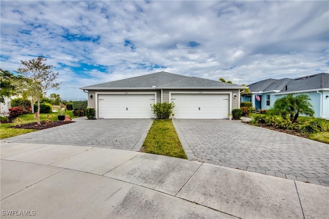 view of front facade with a garage and decorative driveway