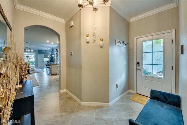 entrance foyer featuring a chandelier, arched walkways, plenty of natural light, and ornamental molding