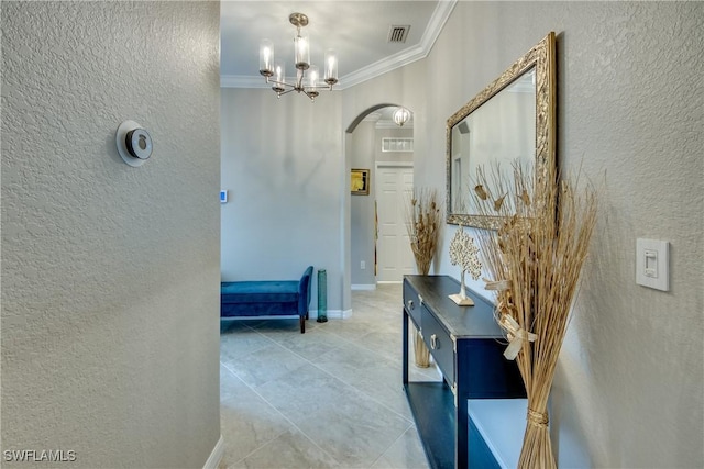 corridor featuring arched walkways, a textured wall, visible vents, baseboards, and ornamental molding