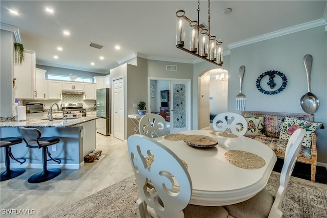 dining space with arched walkways, recessed lighting, visible vents, ornamental molding, and a chandelier