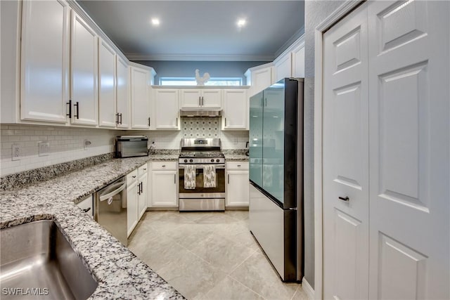 kitchen with ornamental molding, stainless steel appliances, tasteful backsplash, and white cabinetry