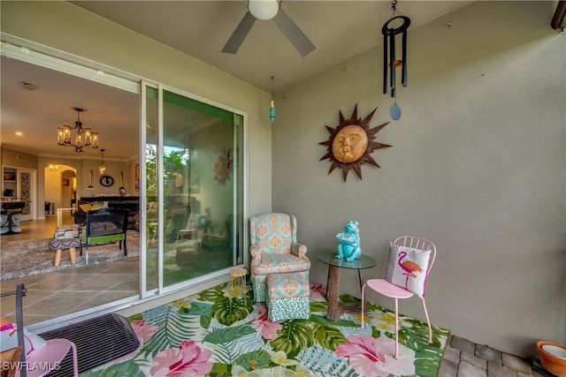 sunroom / solarium featuring arched walkways and a ceiling fan