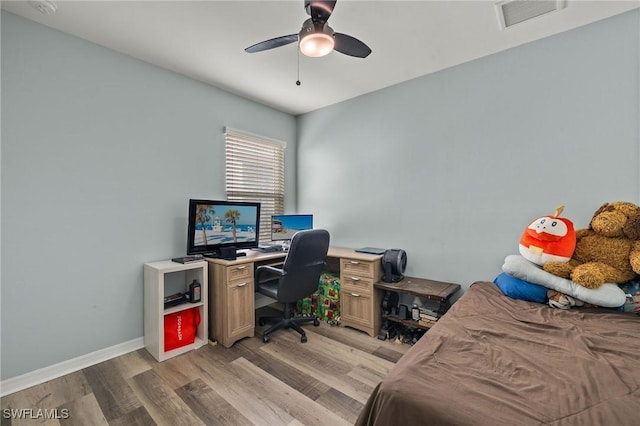 office with light wood-type flooring and ceiling fan