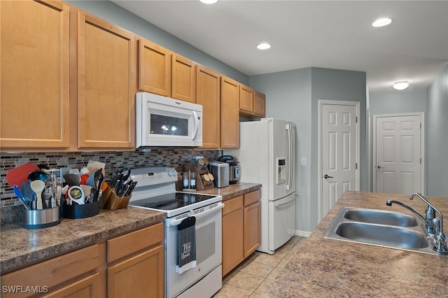 kitchen featuring light brown cabinetry, tasteful backsplash, white appliances, sink, and light tile patterned floors