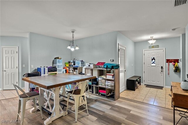 dining area with light hardwood / wood-style flooring and a chandelier