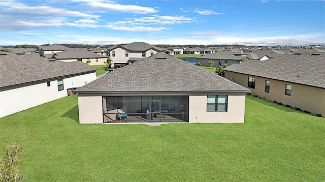 rear view of house with a lawn and a sunroom