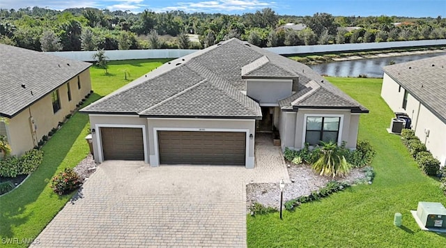 view of front of property featuring central AC, a garage, and a water view