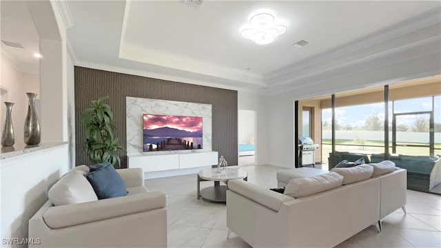 living room with a tray ceiling and light tile patterned floors