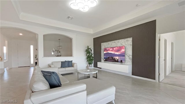 living room with ornamental molding and a tray ceiling