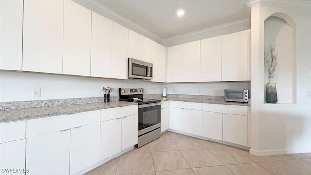 kitchen with white cabinets, stainless steel appliances, ornamental molding, and light tile patterned floors