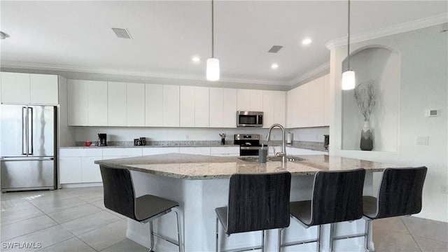 kitchen featuring appliances with stainless steel finishes, hanging light fixtures, white cabinets, and sink