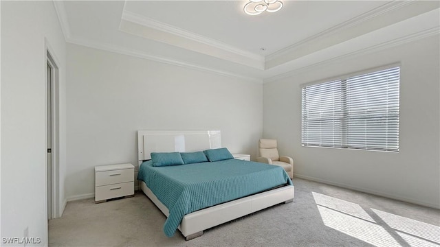 carpeted bedroom featuring crown molding and a tray ceiling