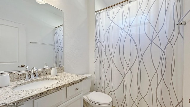 bathroom with toilet, curtained shower, and vanity