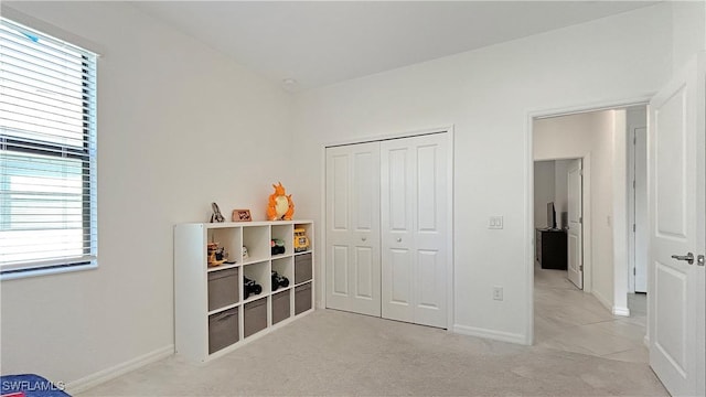 bedroom with light carpet, a closet, and multiple windows