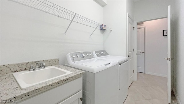 washroom featuring sink, separate washer and dryer, and light tile patterned floors