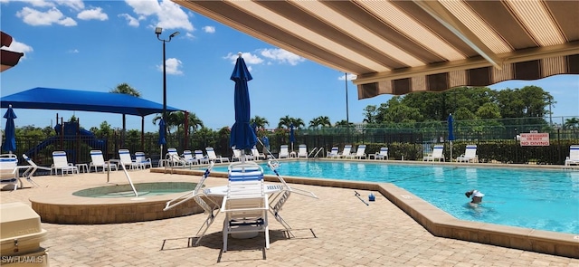 view of pool with a patio and a hot tub