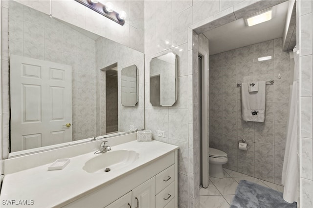 bathroom with tile patterned floors, vanity, tile walls, and toilet