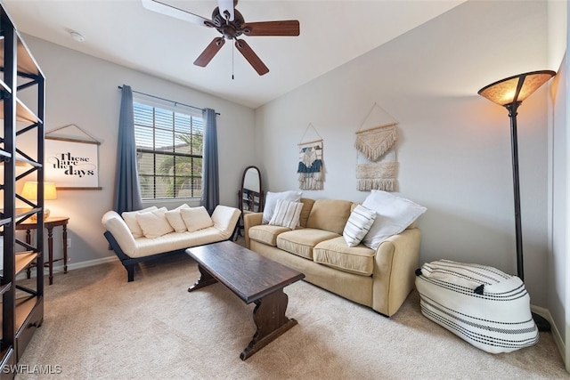 carpeted living area with baseboards and ceiling fan