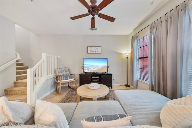 living room with stairs, light tile patterned floors, a ceiling fan, and visible vents