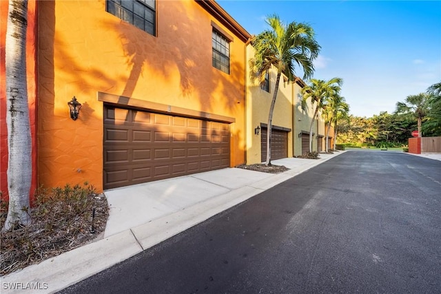 view of home's exterior featuring stucco siding, driveway, and a garage