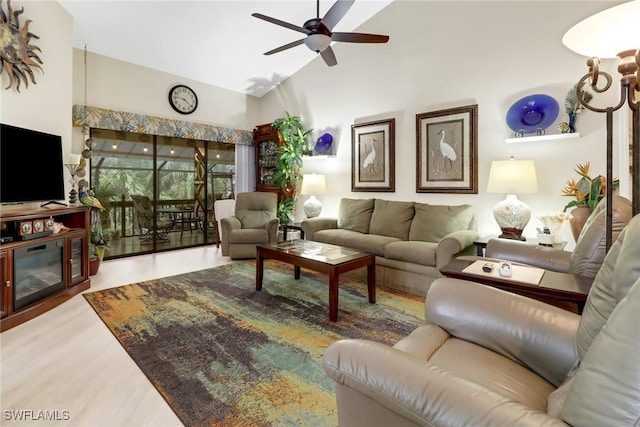 living room featuring high vaulted ceiling, hardwood / wood-style floors, a premium fireplace, and ceiling fan