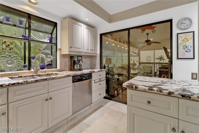 kitchen featuring ceiling fan, dishwasher, decorative backsplash, sink, and light stone countertops