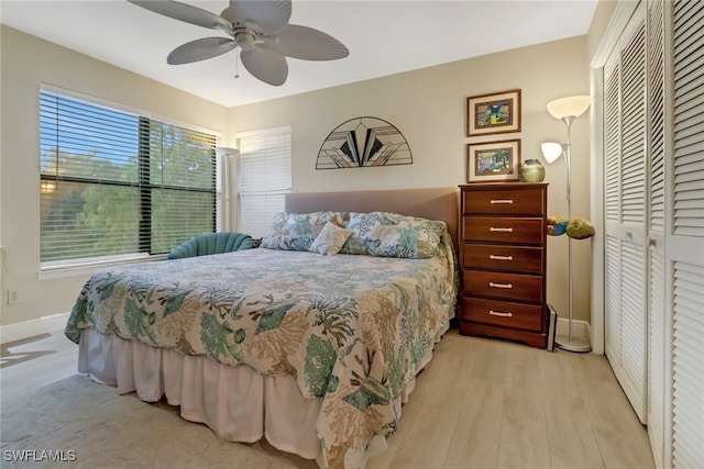 bedroom with ceiling fan, a closet, and light hardwood / wood-style flooring