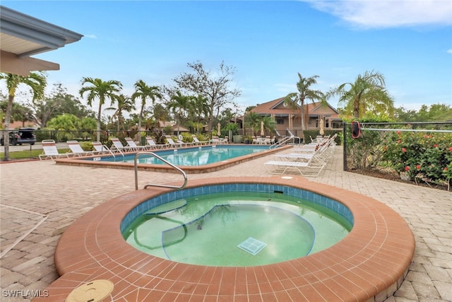 view of swimming pool featuring a community hot tub and a patio