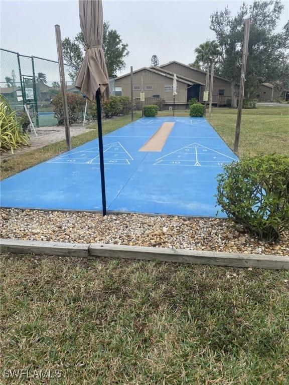 view of sport court with a yard