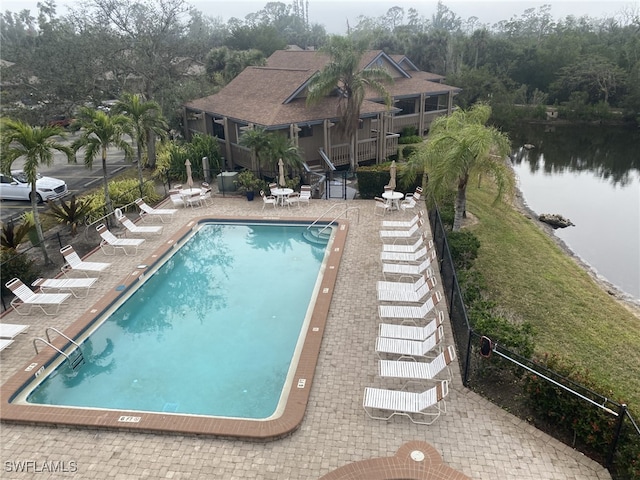 view of swimming pool featuring a patio area and a water view