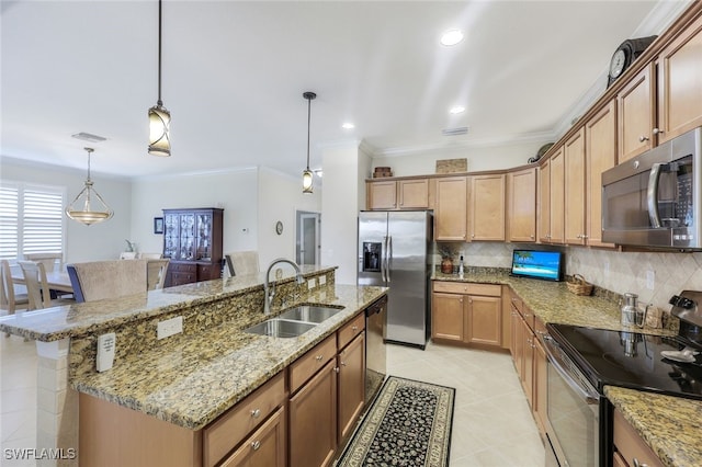 kitchen with a center island with sink, sink, hanging light fixtures, decorative backsplash, and stainless steel appliances