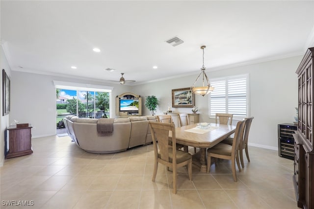 dining room with ceiling fan, light tile patterned flooring, and crown molding