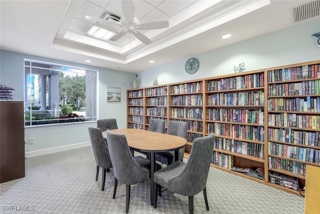 interior space featuring a raised ceiling and ceiling fan