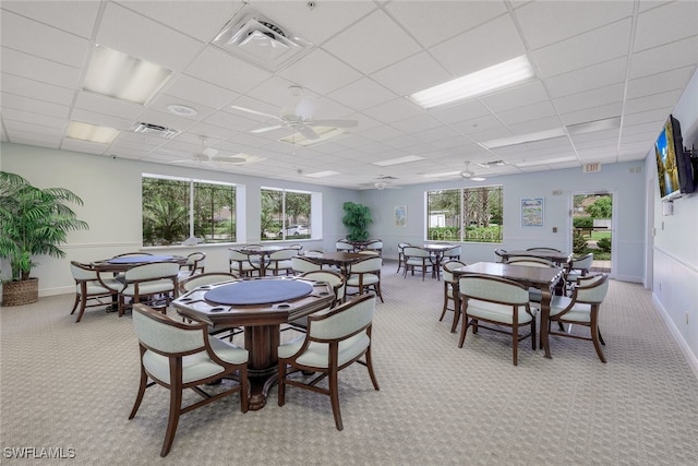 carpeted dining room with a paneled ceiling and ceiling fan