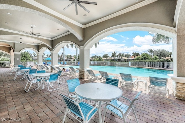 view of patio with ceiling fan and a community pool